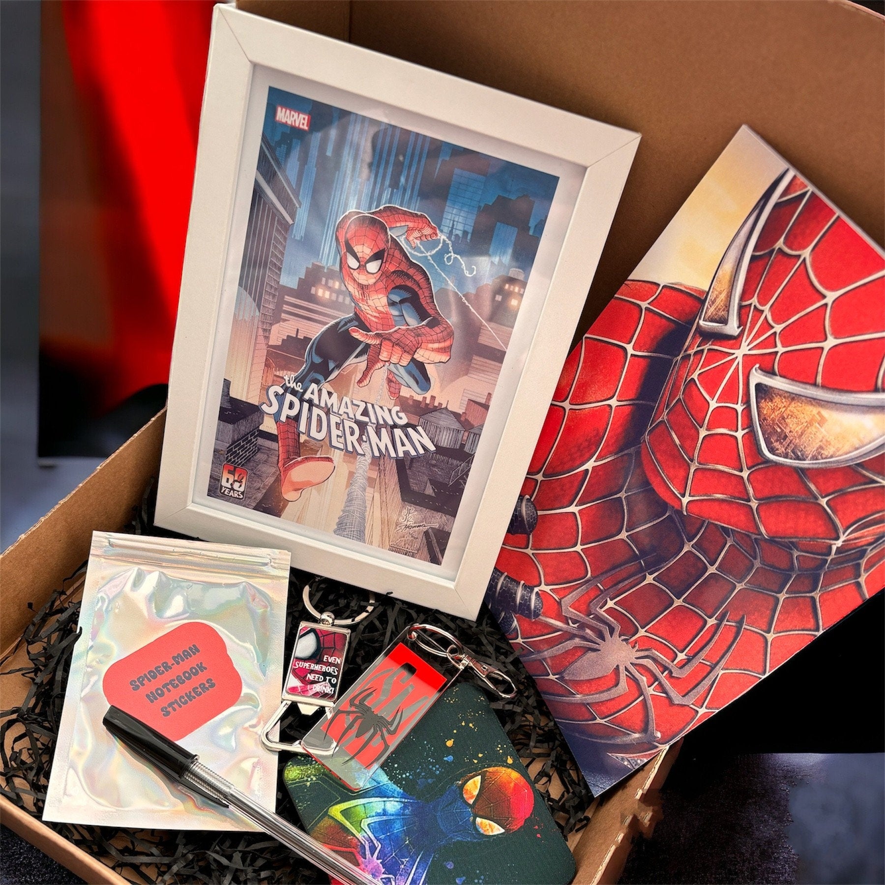 Hand-Made Spider-Man Gift Set - Exclusive 5x7 Foil Print, Notebook, and More!  Our Spider-Man Gift Set is a sensational collection celebrating everyone's favorite wall-crawler! Dive into the superhero universe with a framed 5x7 high-gloss foil print of The Amazing Spider-Man comic cover, accompanied by a range of themed accessories.